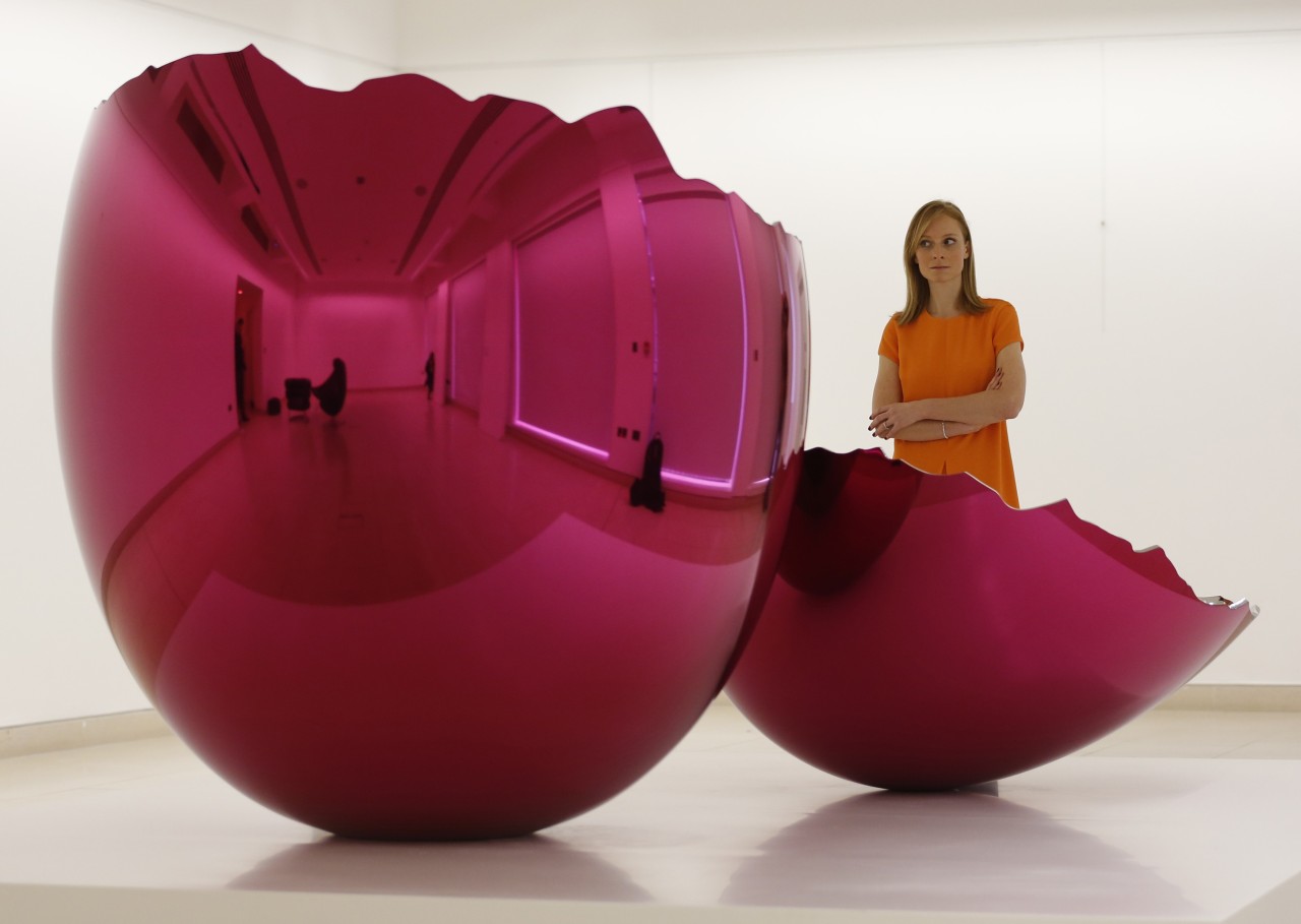 
Una mujer  observa el &#8220;Huevo agrietado (Magenta)&#8221; de Jeff Koons en una exhibición en Christie en Londres. Se espera que la obra cotice 15 millones de libras esterlinas (24 millones de dólares) cuando se subasta el 13 de febrero de 2014. (REUTERS)