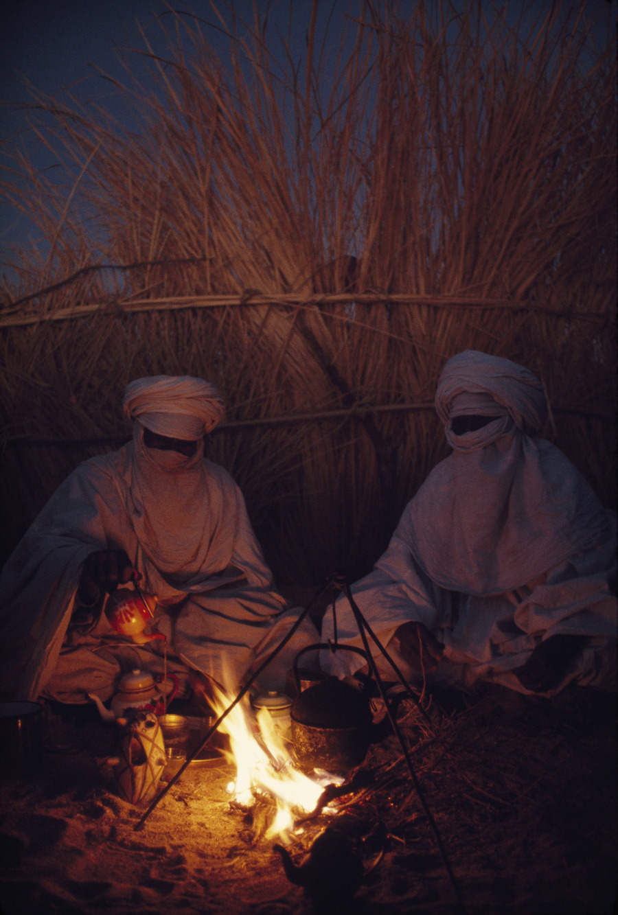 Tuareg goatherds drink tea in their desert shelter at Hassi Izernene, August 1973.Photograph by Thomas J. Abercrombie, National Geographic