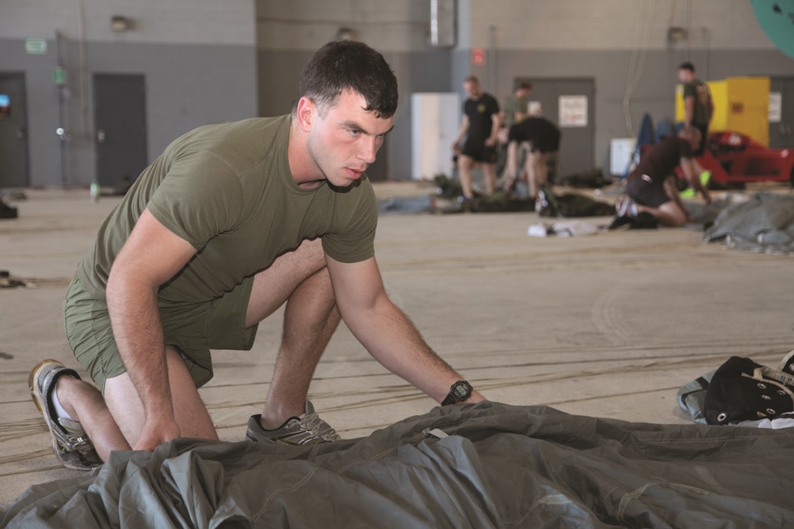 Marine Corps Base Kaneohe Bay, Hawaii - Cpl. Kyle D. Malone packs and prepares his double-bag static line parachute