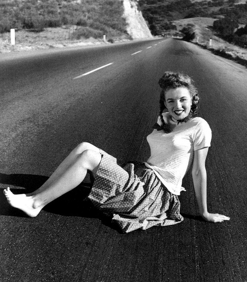 
I said to Norma Jeane: &#8220;Sit on the highway, it represents Life! You have a long way to go!&#8221;
It all started here, in 1945. Norma Jeane was 19; just started modeling. This was her first professional assignment. I was madly in love with her, and wanted to take many, many pictures of her.
Why I wanted that, it&#8217;s a long story, yet to tell.
While photographing this, looking at the tiny little white stars on her red skirt, unconsciously, I began prognosticating to her, that, she will become very famous! That those little stars meant great fame! Yet, I had no idea why I said that! It just happened!

- André de Dienes, photographer &amp; friend
