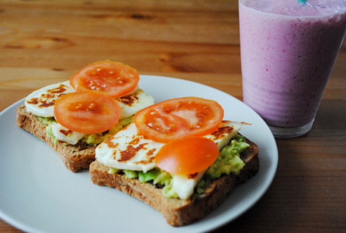 im-undone:

Raspberry and banana smoothie, two whole grain toasts with mashed avocado, grilled halloumi and tomato.
