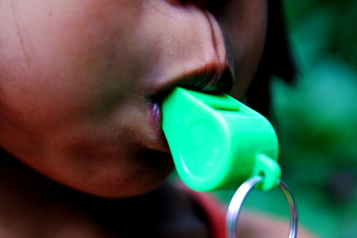 Child blows plastic whistle