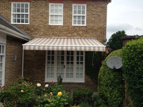One manually operated folding arm awning covered in acrylic material.