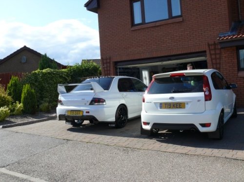 My dad's white Evo 9 beside my mum's white Fiesta ST with matching