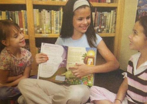 New/old photo of Selena reading to kids when she was younger. 