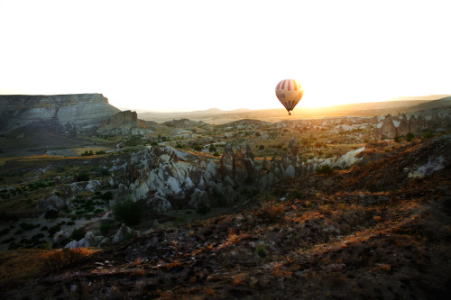 Hot air balloon at sunrise in Cappadocia, Turkey - July, 2012. The whole area was underwater hundreds of thousands of years ago when a volcano erupted, and the lava moved in bubbles throughout the saltwater landscape. As the sea eventually receded, the whipping of the water and wind reshaped Cappadocia into a  surrealist place, complete with its own &#8220;imagination valley&#8221;. This photo was taken last summer when I decided to buy a handful of one-way tickets around the world and traveled alone for the first time. <br /> http://amandapicotte.tumblr.com <br /> http://amandapicotte.tumblr.com/image/39741791860