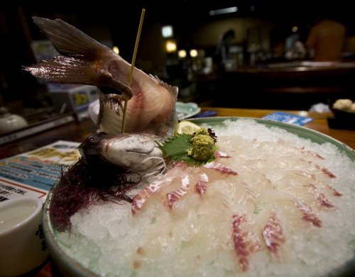 This photo features a fish sashimi dish where the fish was still half alive.