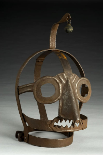 That’s the &#8220;Scold’s Bridle,&#8221; a gruesome mask used as punishment for  &#8220;rude, clamorous woman,&#8221; who are considered to be spending too much  gossiping or quarreling in the Medieval times. It came complete with a  bell on top, no less:

Time spent in the bridle was normally allocated as a  punishment by a local magistrate. The custom developed in Britain in the  1500s, and spread to some other European countries, including Germany.  When wearing the mask it was impossible to speak. This example has a  bell on top to draw even more attention to the wearer, increasing their  humiliation. It was used until the early 1800s as a punishment in  workhouses.
