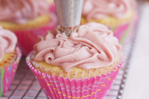 gastrogirl:

decorating cupcakes with raspberry buttercream frosting.
