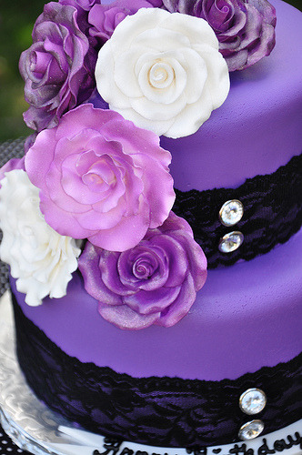 Purple wedding cake with purple and white roses and black lace