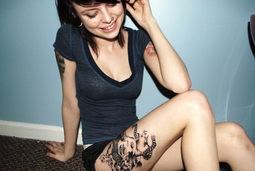 Tattoo on woman's thigh and arms