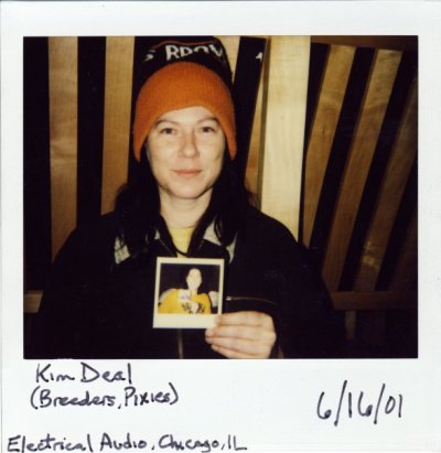 A polaroid of Kim Deal holding a polaroid of Kelley Deal who is holding a