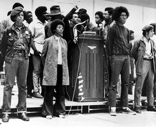 afro-art-chick:  BLACK PANTHER HUEY NEWTON Huey  P. Newton, national defense minister of the Black Panther Party, raises  his clenched fist behind the podium as he speaks at a convention  sponsored by the Black Panthers at Temple University�s McGonigle Hall in  Philadelphia, Pa., Saturday, Sept. 5, 1970.  He is surrounded by  security guards of the movement.  The audience gathered is estimated at  6,000 with another thousand outside the crowded hall.  (AP Photo) 