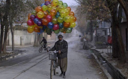 Vendedor afegão vende balões em sua bicicleta, na cidade de Cabul, no Afeganistão