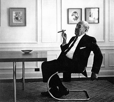 Mies &#8230; the beginning of minimalist luxury&#8230;.
One arm dangling while the other casually holds up the ultimate status symbol &#8230; and within arms reach is a simple Murano glass ashtray. Notice the pocket kerchief and the shine on his shoes. The elegant combination of tubular steel and the cantilever principle  in his MR side chair seemingly leaves the acclaimed architect and Bauhaus director  floating in the air in this carefully composed &#8216;relaxed&#8217; pose&#8230;
