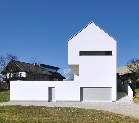 Ancient Meets Artsy in Contemporary Farmhouse Rebuild

Near the medieval Slovenian town of Škofja Loka, a farm property was transformed by the replacement of an ancient farm building with this crisp, modern three-story home. The home, built by Arhitetektura d.o.o., sits in exactly the same location as the farm building it replaced, sharing the very same dimensions, with the same slope used as a prominent influence in the home’s shape.

