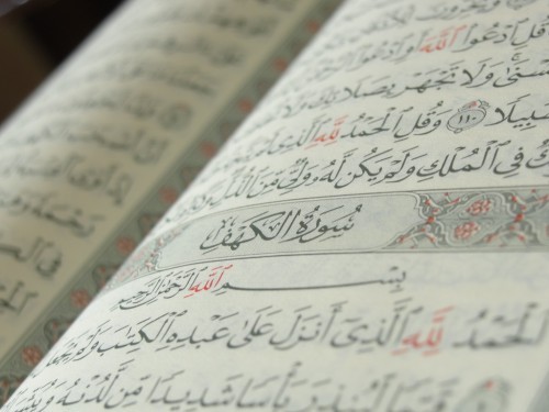 Photo of the Beginning of Surat al-Kahf on a Book of Quran | IslamicArtDB