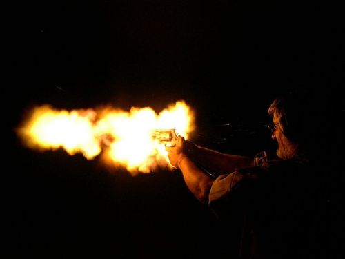 Man fires his handgun at night