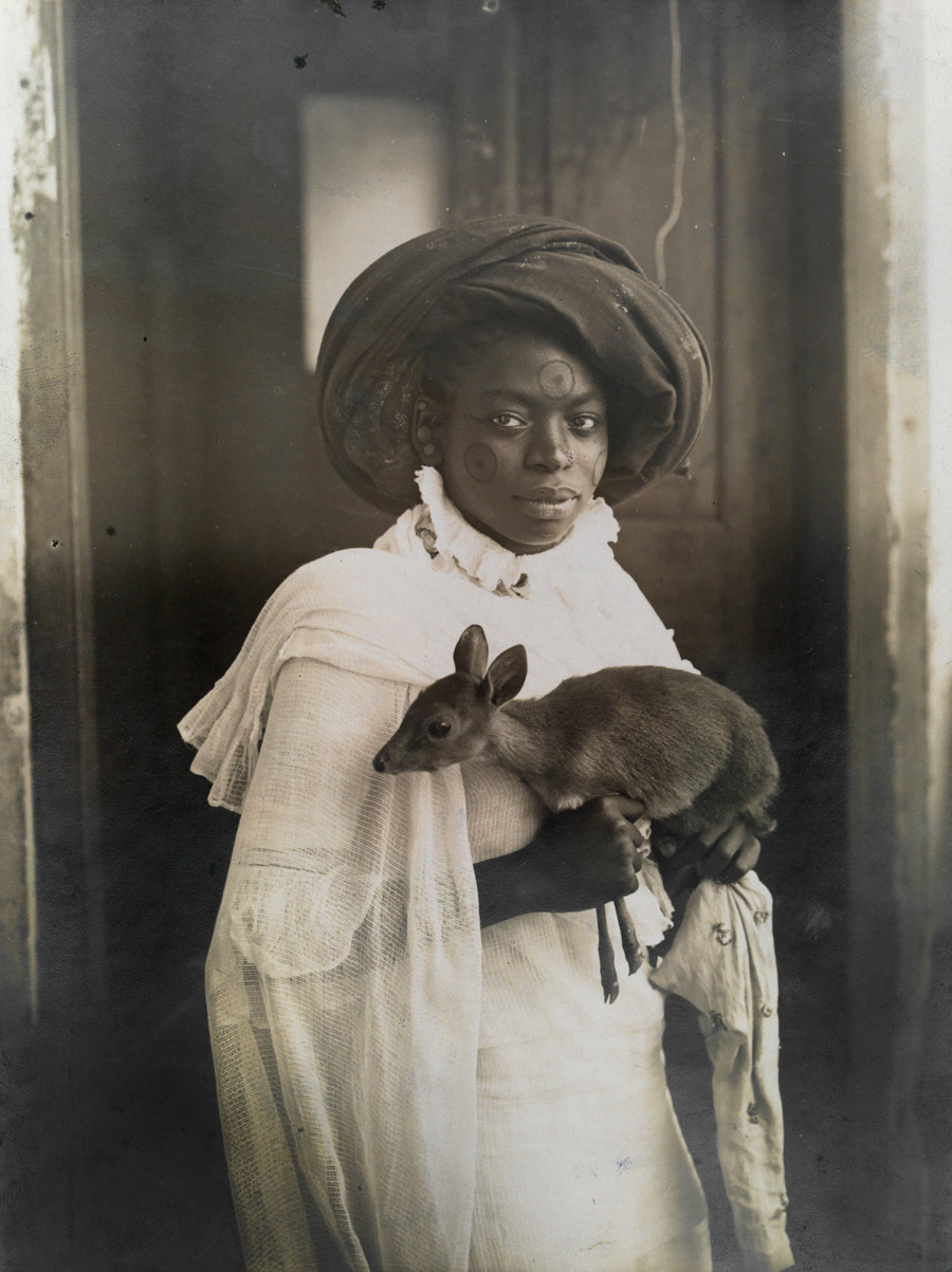 A young Kenyan woman holds her pet deer in Mombassa, March 1909.Photograph by Underwood and Underwood