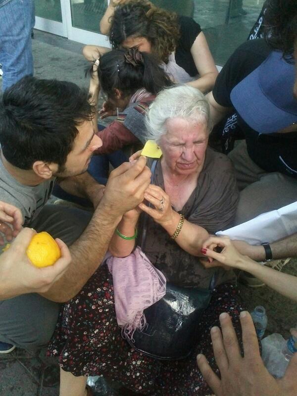 An elderly woman who received her share of tear gas is helped by protesters.