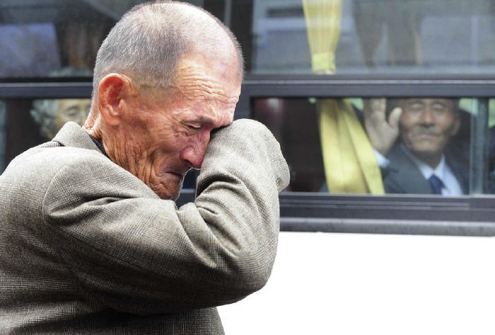 historicallysound: A North Korean man waves his hand as a South Korean relative weeps, following a luncheon meeting during inter-Korean temporary family reunions at Mount Kumgang resort October 31, 2010. Four hundred and thirty-six South Koreans were allowed to spend three days in North Korea to meet their 97 North Korean relatives, whom they had been separated from since the 1950-53 war. 