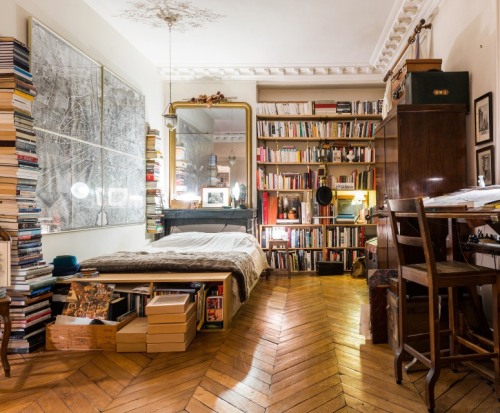 bookshelfporn: Bookshelves and stacks of books in this amazing Paris studio apartment featured in The Village.